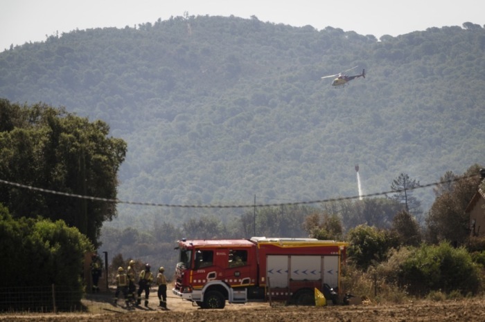 Ein Löschhubschrauber der Feuerwehr ist bei einem Waldbrand nahe der katalanischen Stadt Calonge im Nordosten Spaniens im Einsatz. Foto: EPA/David Borrat