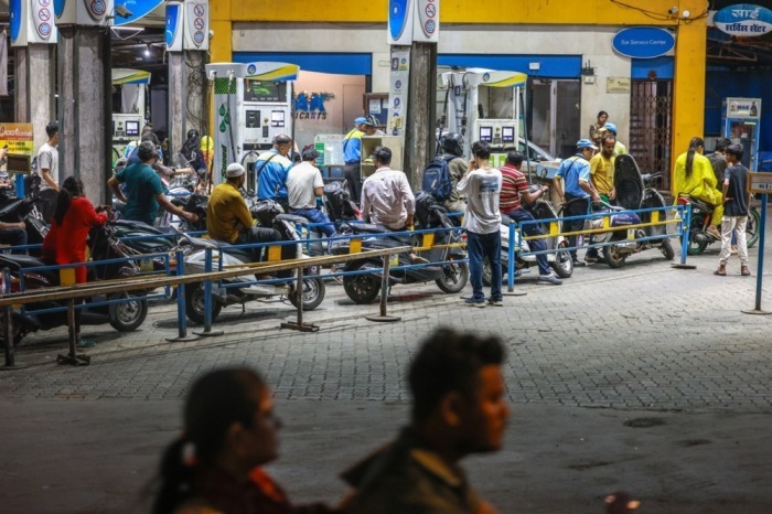Motorradfahrer warten an einer Tankstelle in Mumbai. Premierminister Modi ruft wegen der Nahostkrise zum Spritsparen auf. Foto: EPA/Divyakant Solanki