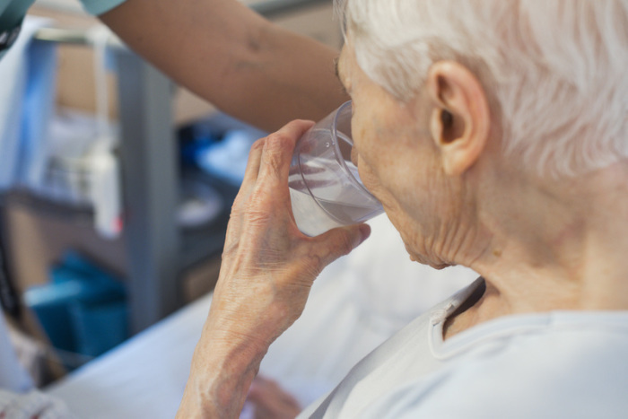 Eine ältere Frau trinkt aus einem Glas Wasser. Es gibt einen Zusammenhang zwischen Extremtemperaturen und Übersterblichkeit. Foto: Jana Bauch/dpa