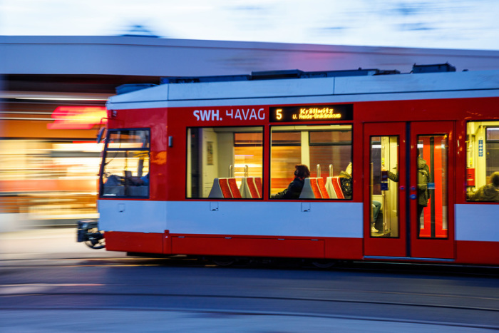 Fahrgäste sitzen im morgendlichen Berufsverkehr in einer Straßenbahn. Foto: Jens Schlüter/dpa