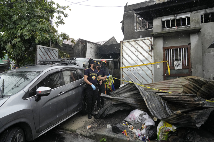Polizisten sperren den Ort eines Wohnhausbrandes ab. Bei einem Brand in einem zweistöckigen Haus auf den Philippinen sind mindestens 16 Menschen ums Leben gekommen. Foto: Aaron Favila/Ap/dpa