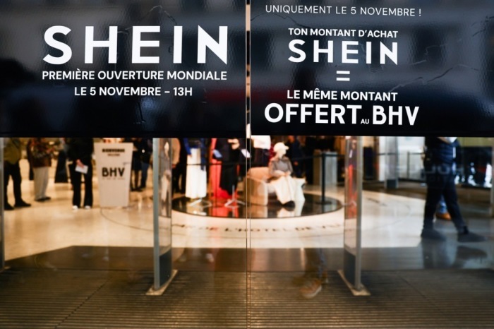 Hinweisschilder bewerben Eröffnungsaktionen im ersten Shein-Store in Paris, dessen Start wegen Kontroversen und Protesten kritisiert wird. Foto: epa/Teresa Suarez