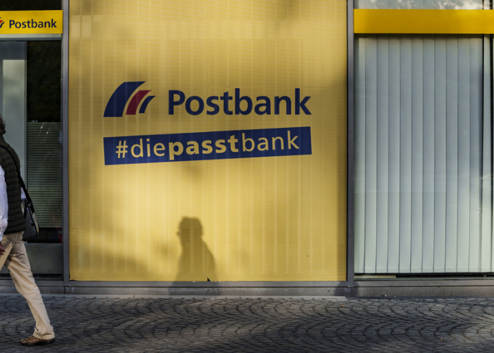 Ein Mann geht an einer Postbank-Filiale vorbei. Foto: Andreas Arnold/dpa