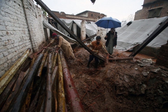 Menschen sammeln ihre Habseligkeiten aus ihrem Haus ein, das nach heftigen Regenfällen in Peshawar eingestürzt ist. Foto: epa/Arshad Arbab