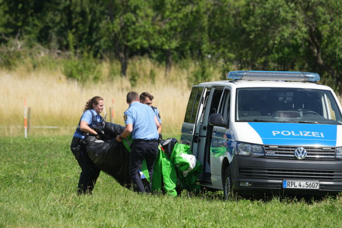 Polizeibeamte transportieren die Hülle einer Hüpfburg ab. Foto: Thomas Frey/dpa