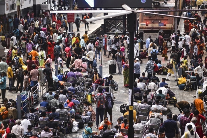 Reisende in Indien warten im Hauptbahnhof von Chennai auf einen Zug. Foto: epa/Idrees Mohammed
