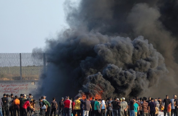 Während der Zusammenstöße mit israelischen Truppen an der Ostgrenze des Gazastreifens versammeln sich palästinensische Demonstranten in der Nähe der Grenzmauer. Foto: epa/Mohammed Saber