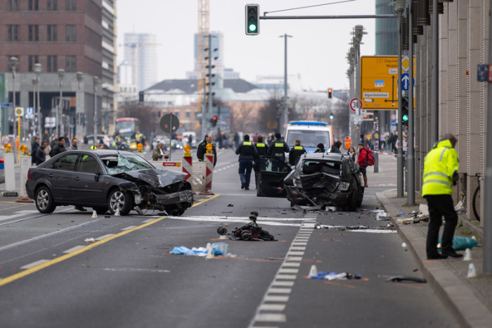 Polizisten stehen an einer Unfallstelle in der Leipziger Straße. Foto: Christophe Gateau/dpa