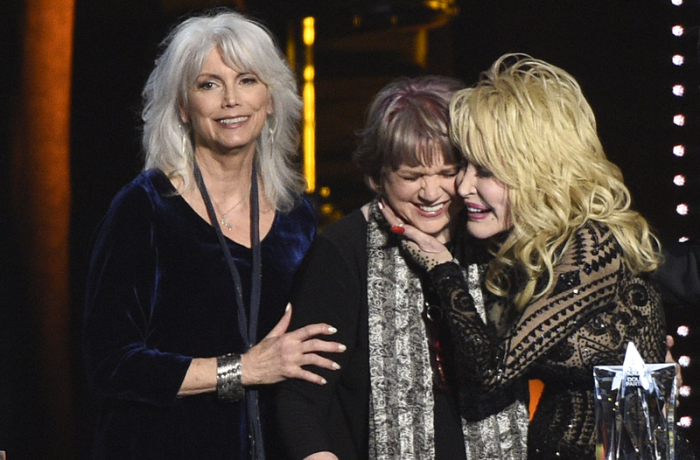 Dolly Parton wird bei ihrer Ehrung zur „MusiCares Person of the Year“ von Emmylou Harris und Linda Ronstadt umarmt. Foto: Chris Pizzello/Invision/ap/dpa