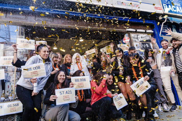 Die Gewinner des ersten Preises der außerordentlichen spanischen Weihnachtslotterie 2023 mit der Nummer 88008 feiern ihr Glück in der Verwaltung Dona Manolita. Foto: Carlos Luján/Europa Press/dpa