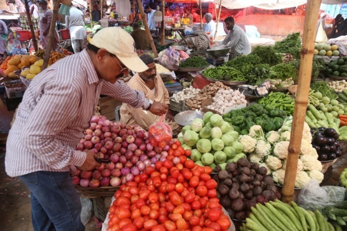 Eine Verkäuferin verkauft Gemüse auf einem Großmarkt in Karatschi, Pakistan. Foto: epa/Rehan Khan
