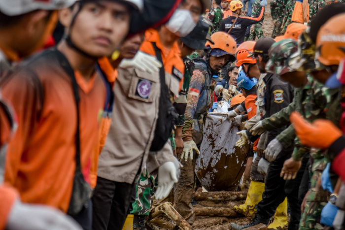 Rettungskräfte tragen die Leiche eines Erdrutschopfers im Dorf Pasirlangu. Starke Regenfälle und extreme Wetterbedingungen hatten Erdrutsche in der Region verursacht. Foto: Dimas Rachmatsyah/Zuma Press Wire/dpa