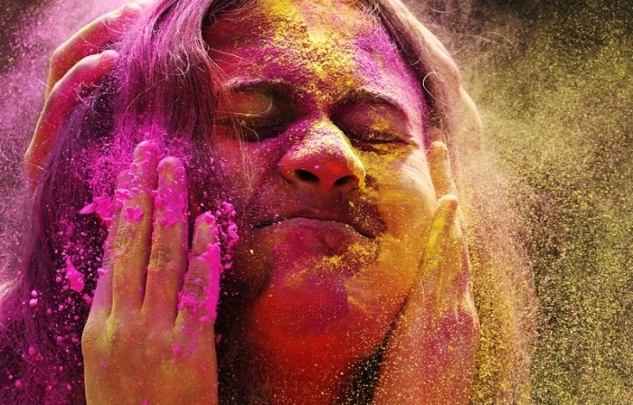 Eine Feiernde wird mit farbigem Pulver während der Holi-Feierlichkeiten beschmiert. Foto: Rajanish Kakade/Ap/dpa