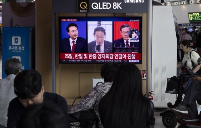 Menschen sehen in einem Bahnhof in Seoul einen Nachrichtenbeitrag über den südkoreanischen Präsidenten Yoon Suk Yeol (L), den japanischen Premierminister Fumio Kishida (C) und den chinesischen Premierminister Li Qiang ... Foto: epa/Jeon Heon-kyun