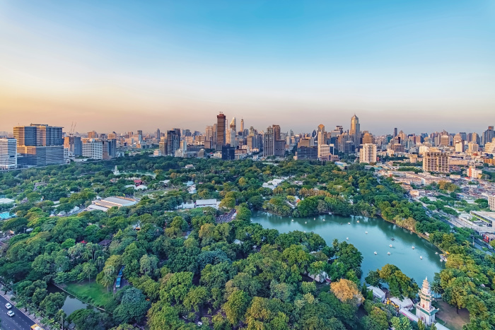 Der Lumphini Park bildet mit seinem See und den alten Bäumen eine grüne Ruhezone im Herzen Bangkoks. Foto: Stockbym/Adobe Stock