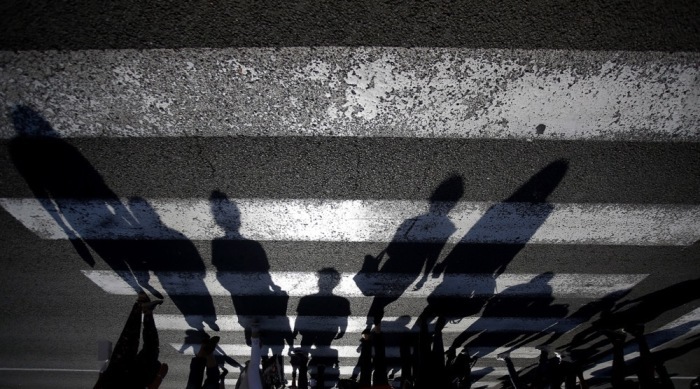 Die Fußgänger werfen ihre Schatten, wenn sie eine Straße in Belgrad überqueren. Foto: epa/Novak Djurovic