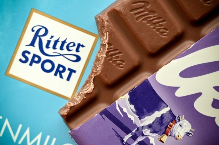 Eine geteilte Milka-Schokolade liegt auf einer Ritter-Sport-Tafel. Der BGH entschied im Streit um die Quadrat-Form. Foto: EPA/Sascha Steinbach