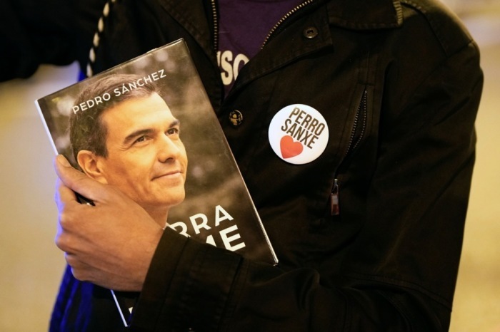 Ein Unterstützer der Sozialisten hält ein Exemplar des Buches von Spaniens Premierminister Pedro Sanchez in der Hand. Foto: epa/Borja Sanchez-trillo