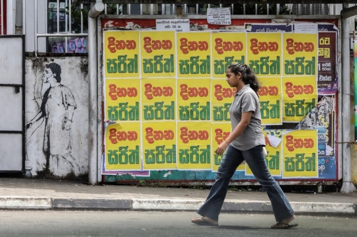 Eine sri-lankische Frau geht an Wahlplakaten der Kandidaten für die bevorstehenden Präsidentschaftswahlen in Colombo vorbei. Foto: epa/Chamila Karunarathne