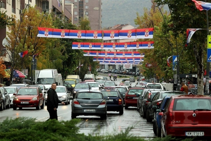 Fahrzeuge bewegen sich auf den mit serbischen Flaggen geschmückten Straßen in Nord-Mitrovica, Kosovo. Foto: epa/Djordje Savic