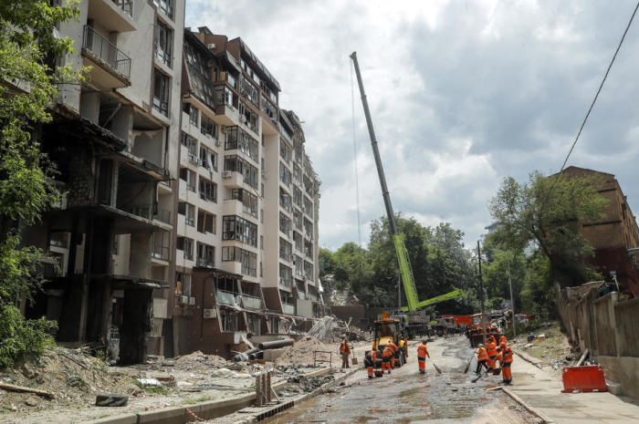 Kommunale Arbeiter säubern Trümmer vor einem nach russischen Luftangriffen beschädigten Wohnhaus im Kiewer Stadtteil Schewtschenkiwskiy. Foto: epa/Sergey Dolzhenko