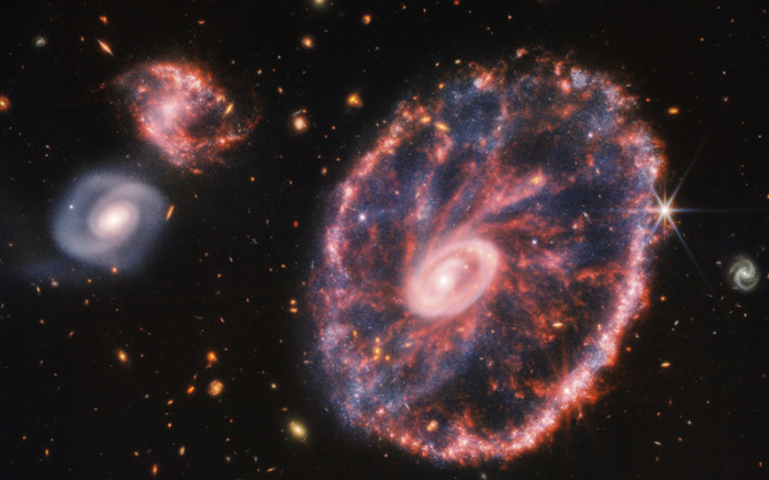 Dieses von der NASA zur Verfügung gestellte Handout-Foto zeigt eine große, rosa-blau gesprenkelte Galaxie, die einem Rad mit einem kleinen, inneren Oval ähnelt. Foto: Uncredited