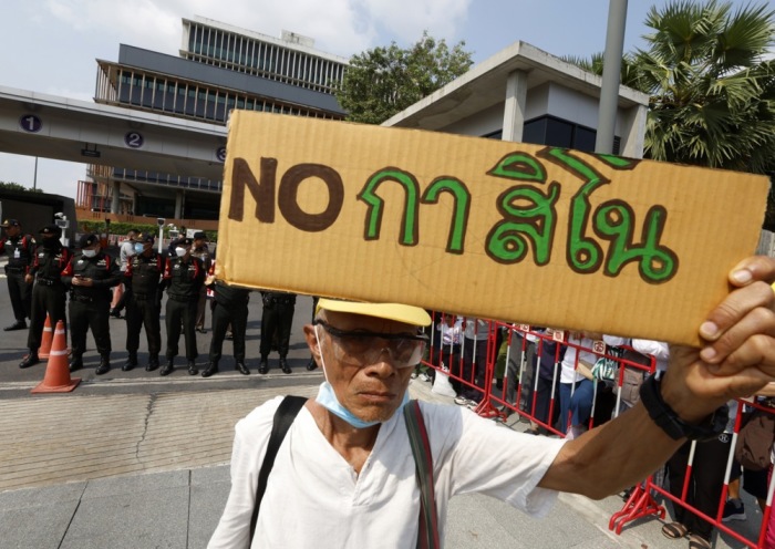 Ein Demonstrant protestiert mit einem Schild gegen den geplanten Bau von staatlich regulierten Spielcasinos. Foto: epa-efe/Narong Sangnak