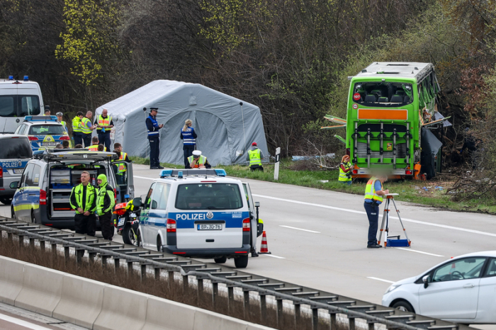 Der verunglückte Bus ist an der Unfallstelle auf der A9 zu sehen. Bei dem Unfall mit einem Reisebus auf der A9 nahe Leipzig sind mindestens fünf Menschen ums Leben gekommen. Dies teilte die Polizei auf Anfrage mit. Zudem g... Foto: Jan Woitas/dpa