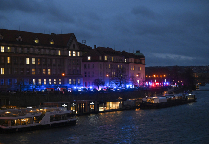 Feuerwehrfahrzeuge und Krankenwagen stehen am Ufer vor der Karlsuniversität. An einer Hochschule in der Prager Innenstadt sollen Schüsse gefallen sein. Foto: Deml Ondøej/Ctk/dpa