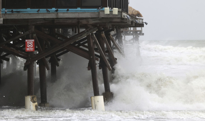 Wellen brechen am Cocoa Beach Pier, als der Sturm «Nicole» aufzieht. Foto: Ricardo Ramirez Buxeda/Orlando Sentinel/dpa