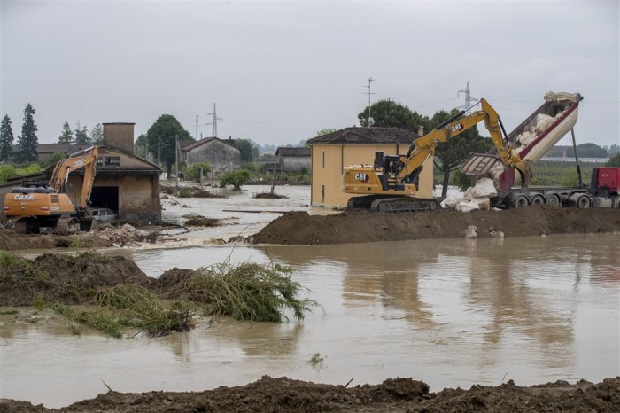 Ein Bagger versucht, den Damm eines Flusses wieder aufzubauen, nachdem dieser gebrochen war. Foto: EPA-EFE/Bove-zani