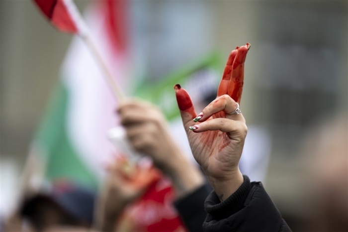 Die rot angemalte Hand einer Frau bei einer Kundgebung für die Freiheit der iranischen Frauen. Foto: epa/Anthony Anex