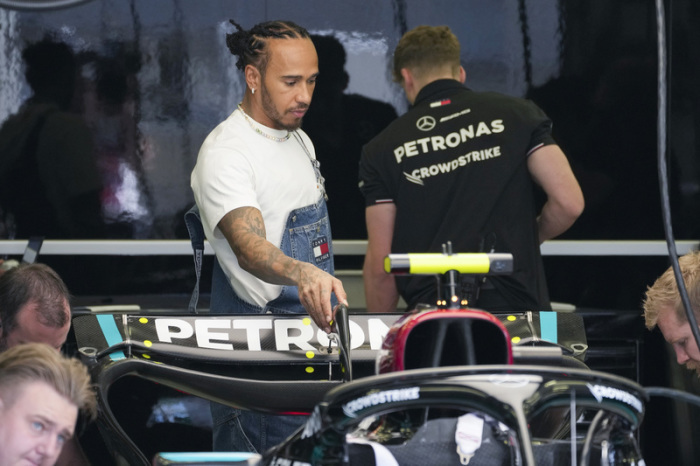 Lewis Hamilton (r) aus Großbritannien vom Team Mercedes arbeitet mit seiner Boxencrew vor dem ersten Training an der Rennstrecke. Foto: Darko Bandic/Ap/dpa