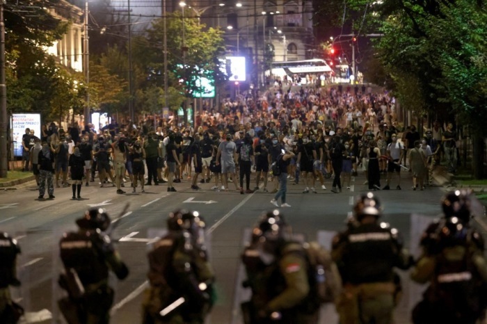 Demonstranten stehen in Belgrad Polizisten in Schutzausrüstung gegenüber, während Proteste eskalieren. Foto: EPA/Andrej Cukic