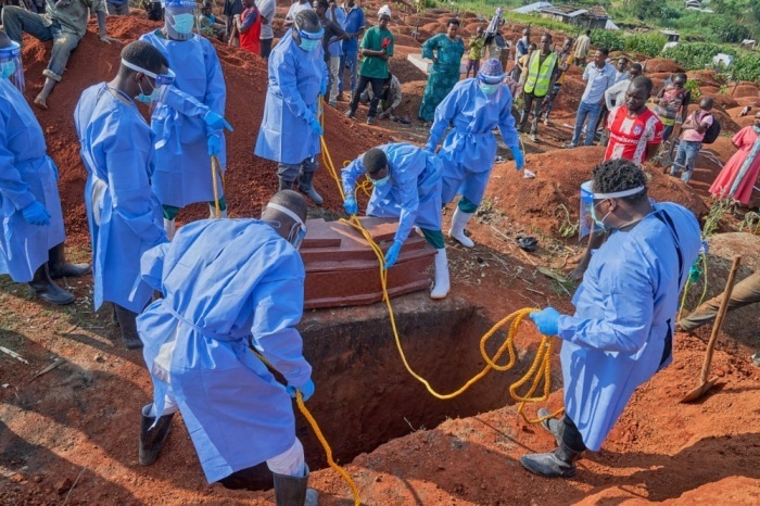 Mitarbeiter lassen bei einer Beisetzung in Bunia den Sarg eines Ebola-Opfers in ein Grab hinab. Foto: EPA/Dieudonne Dirole