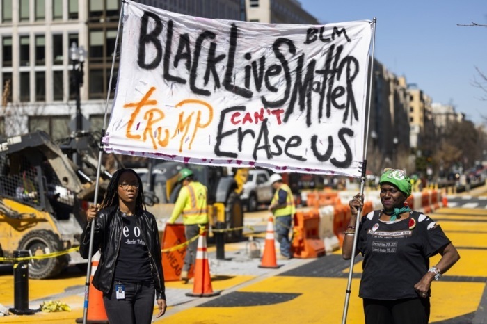 Protestler halten ein Schild, während die örtlichen Behörden mit dem Wiederaufbau des Black Lives Matter (BLM) Plaza gegenüber dem Weißen Haus in Washington beginnen. Foto: epa/Jim Lo Scalzo