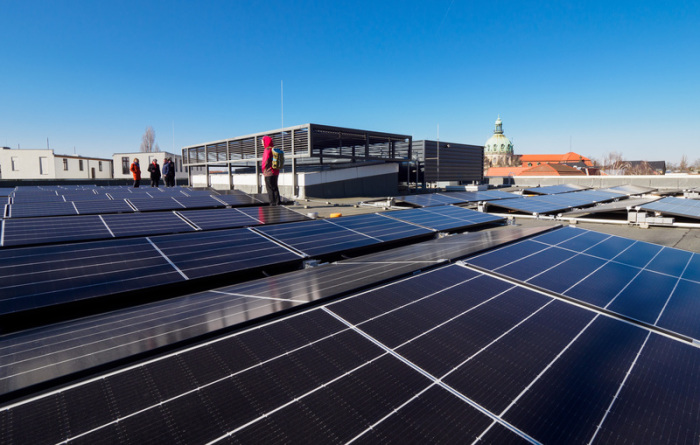 Eine Photovoltaik-Anlage ist seit etwa einem Monat auf dem Dach des Helmholtz-Gymnasiums installiert. Im Hintergrund ist das Dach des Rathauses zu sehen. Foto: Soeren Stache/dpa-zentralbild/dpa
