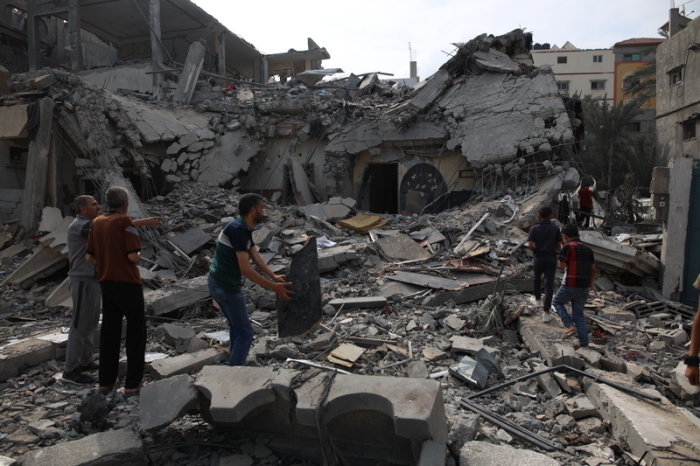 Menschen stehen inmitten der Trümmer eines zerstörten Hauses in der Stadt Deir el-Balah im Zentrum des Gazastreifens. Foto: XinHua/dpa