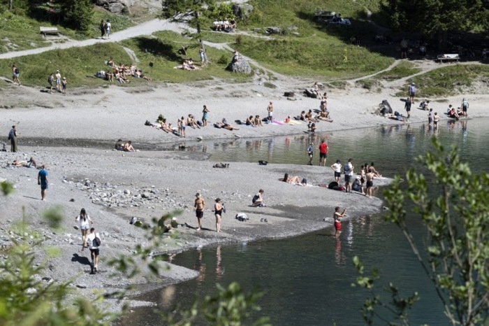 Touristen kühlen sich während der Hitzewelle im Oeschinensee bei Kandersteg im Berner Oberland ab. Foto: epa/Anthony Anex