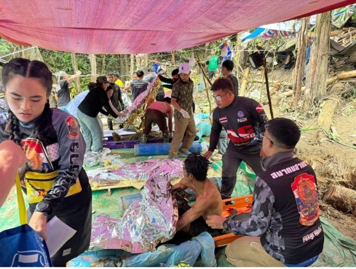 Rettungskräfte versorgen vier laotische Männer mit Rettungsdecken und leisten Erste Hilfe, nachdem sie aus einer überfluteten Höhle in der Provinz Xaysomboun gerettet wurden. Foto: epa/Thailand Rescue Diver/ Facebook Handout