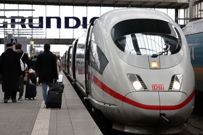 Fahrgäste gehen im Münchner Hauptbahnhof an einem Zug vorbei. Foto: epa/Anna Szilagyi