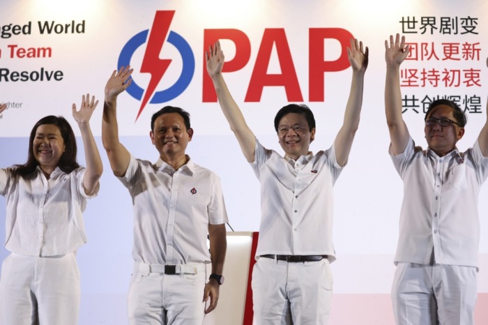 Singapurs künftiger Premierminister Lawrence Wong winkt am Wahlabend mit seinem Team den jubelnden Anhängern zu. Foto: epa/How Hwee Young