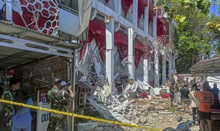 Menschen begutachten Schäden an einem Gebäude nach einem schweren Erdbeben in Manado. Behörden warnen vor einem möglichen Tsunami. Foto: epa/Basarnas / Handout