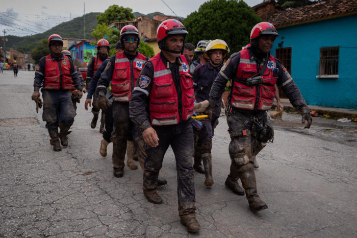 Rettungs- und Feuerwehrleute führen Arbeiten nach dem Überlaufen des Flusses Los Patos in Las Tejerias im Bundesstaat Aragua durch. Foto: epa/Rayner Pena R.