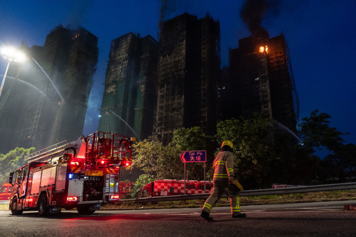 Ein Feuerwehrmann geht am Brandort des Wang Fuk Court vorbei, einer Wohnsiedlung im Stadtteil Tai Po. Foto: Chan Long Hei/Ap/dpa