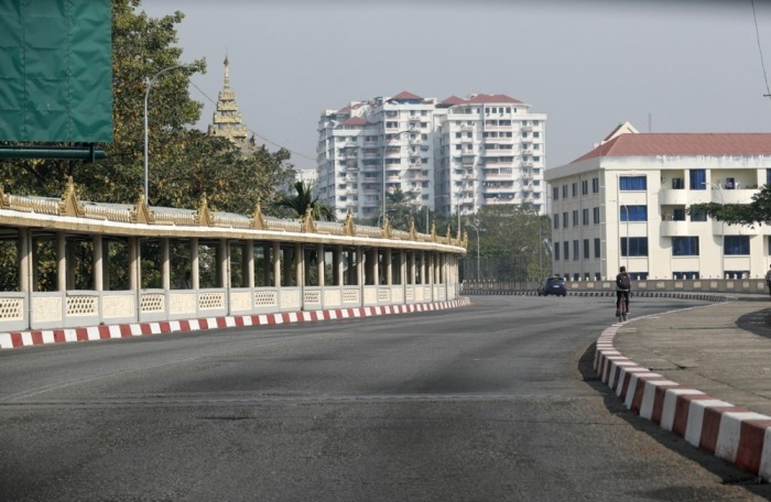 Ein Auto fährt auf einer leeren Straße in der Innenstadt von Yangon. Foto: epa/Stringer