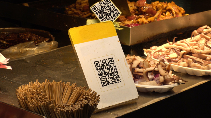 Ein QR-Code-Zahlungssystem wird an einer Verkaufsstelle in Thailand genutzt – internationale Touristen greifen zunehmend auf „Thai QR“ zurück. Bild: StreetVJ/Adobe Stock