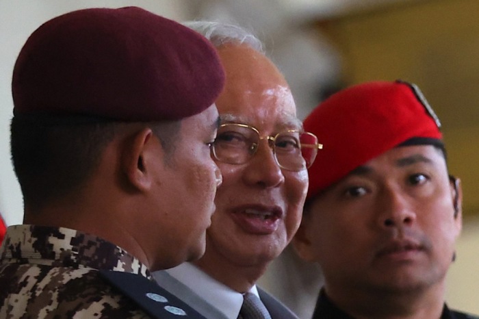 Der frühere malaysische Premierminister Najib Razak wird von Polizisten zum Obersten Gericht in Kuala Lumpur begleitet. Foto: epa/Fazry Ismail