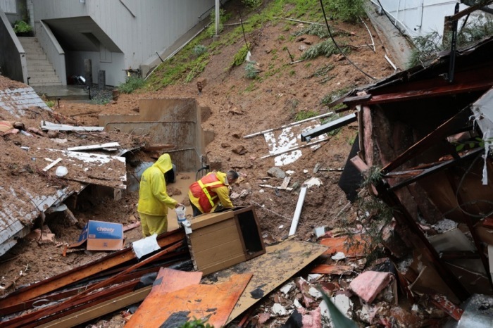 Arbeiter eine Gasleitung eines eingestürzten Hauses, das sich von seinem Fundament gelöst hat und einen Hügel hinabstürzt, während ein heftiger atmosphärischer Flusssturm Südkalifornien trifft. Foto: epa/Allison Dinner