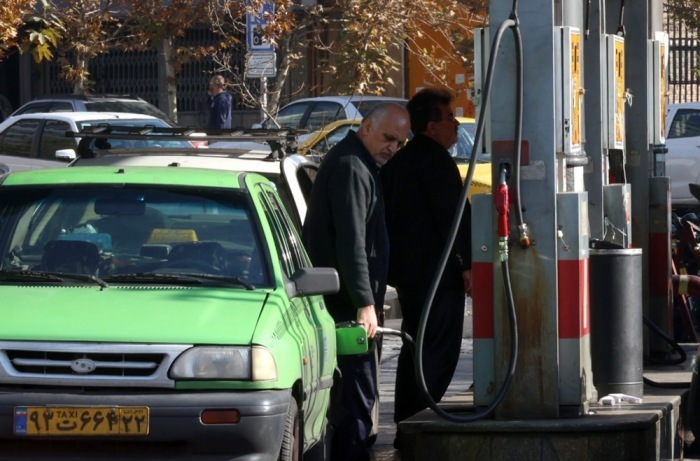Menschen tanken an einer Zapfsäule in Teheran. Iran führt ein dreistufiges Benzinpreissystem ein, das je nach Verbrauch höhere Preise vorsieht. Foto: epa/Abedin Taherkenareh
